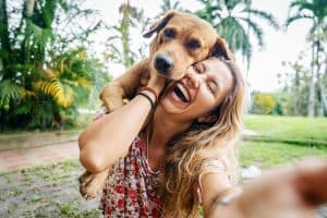 A woman posing with her dog outside