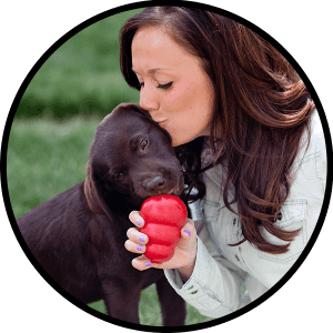 Woman kissing her dog and giving a KONG Classic