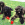 Drei schwarze Hunde sitzen im Gras, jeder mit einem KONG Classic.