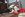 brown and white dog laying on the floor chewing on a KONG red dog toy with a Valentine's Day theme backdrop